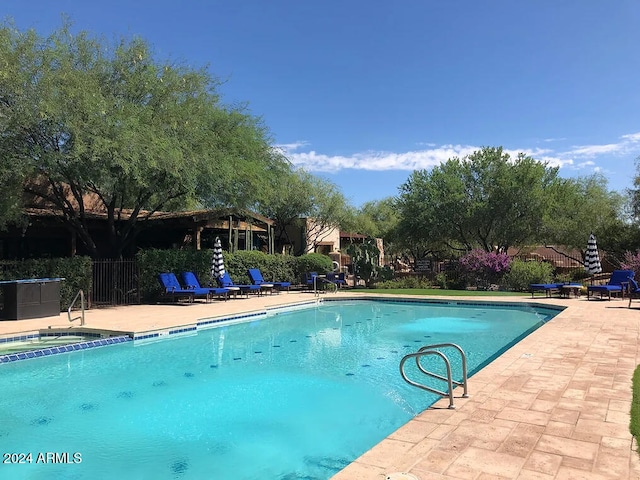 view of swimming pool with a patio and a hot tub