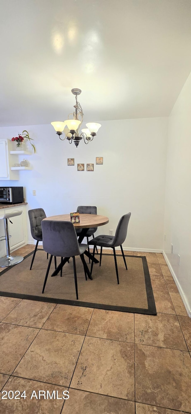 tiled dining area with a notable chandelier