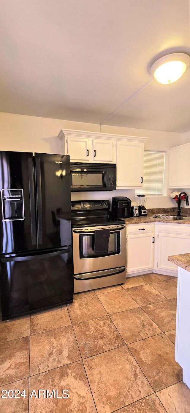 kitchen featuring black appliances, light tile patterned floors, and white cabinets