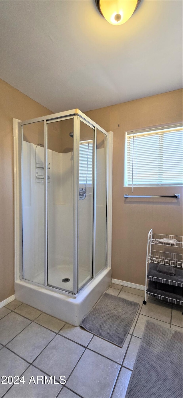 bathroom with tile patterned flooring and a shower with door