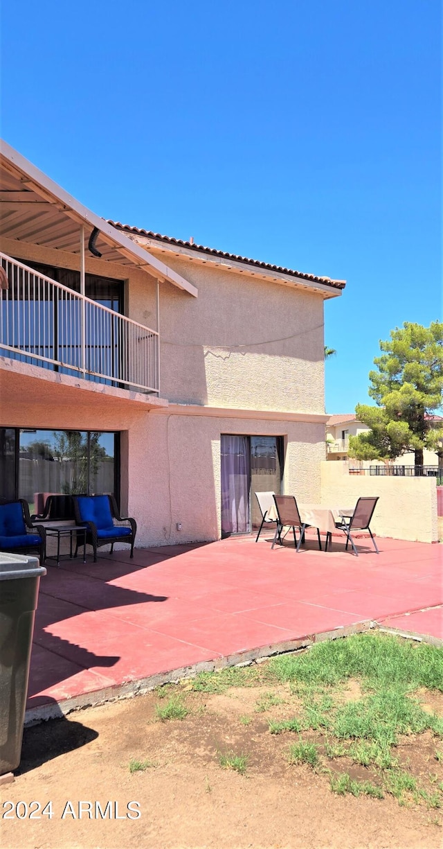 back of house with a balcony and a patio