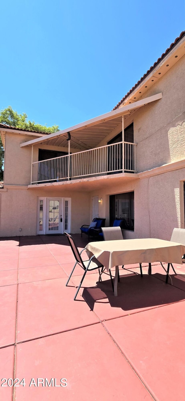 rear view of property featuring a patio and a balcony