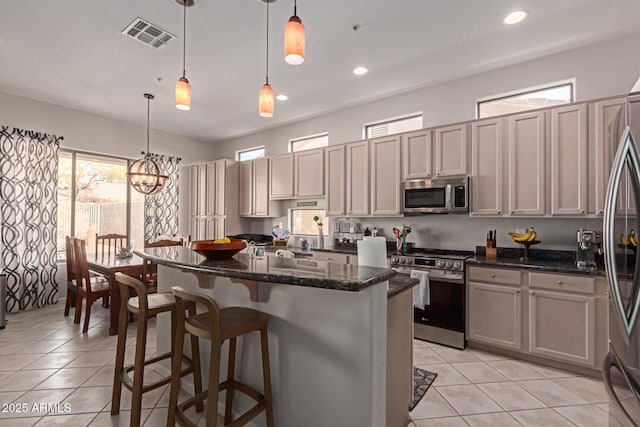 14806 E Crested Crown, Fountain Hills, AZ 85268 - kitchen with appliances with stainless steel finishes, light tile patterned floors, a kitchen island, dark stone counters, and a breakfast bar area