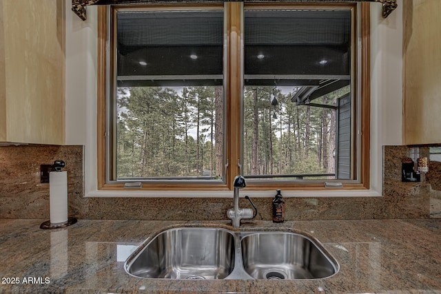 kitchen featuring plenty of natural light, stone countertops, and a sink