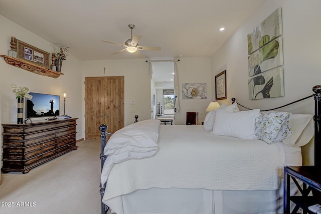 bedroom featuring light carpet and a ceiling fan