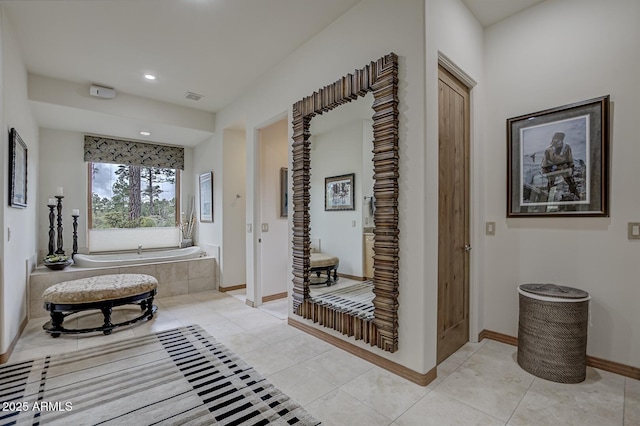 corridor with light tile patterned floors, visible vents, baseboards, and recessed lighting