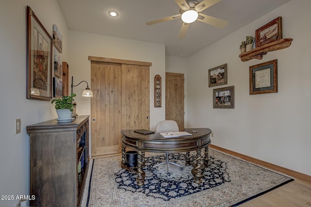 home office featuring ceiling fan, baseboards, and light wood-style flooring