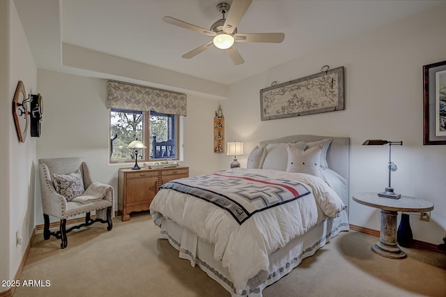 bedroom featuring baseboards, light colored carpet, and a ceiling fan