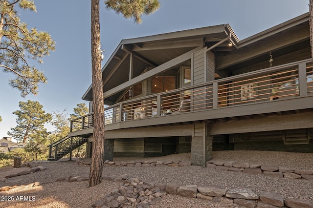 rear view of house featuring stairway and a deck