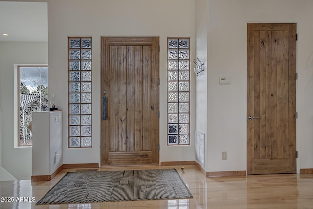 foyer entrance featuring visible vents and baseboards