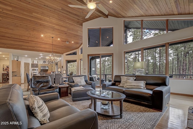 living area featuring wood finished floors, baseboards, high vaulted ceiling, wooden ceiling, and ceiling fan with notable chandelier