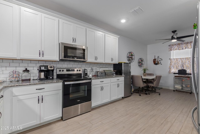 1463 W Pinkley Ave, Coolidge, AZ 85128 - kitchen featuring appliances with stainless steel finishes, backsplash, a ceiling fan, white cabinetry, and light stone countertops