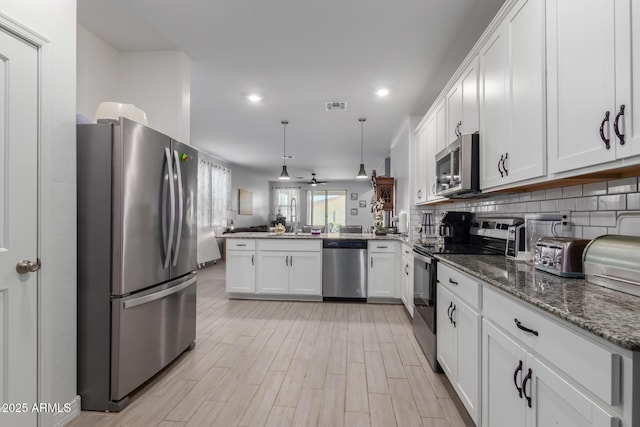 1463 W Pinkley Ave, Coolidge, AZ 85128 - kitchen featuring appliances with stainless steel finishes, open floor plan, a peninsula, white cabinets, and recessed lighting