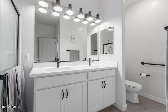 1463 W Pinkley Ave, Coolidge, AZ 85128 - bathroom with toilet, double vanity, wood finished floors, and baseboards