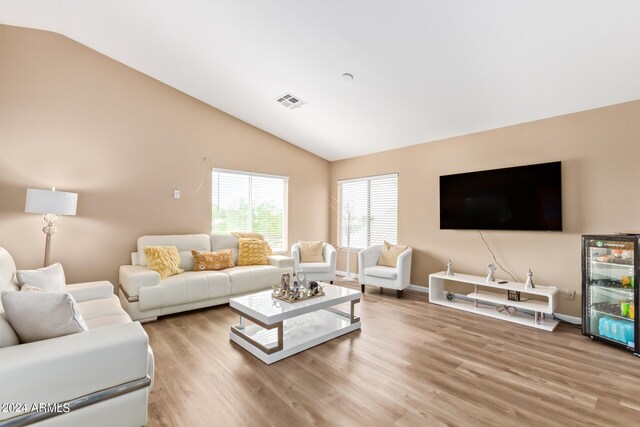 living room with high vaulted ceiling and light wood-type flooring