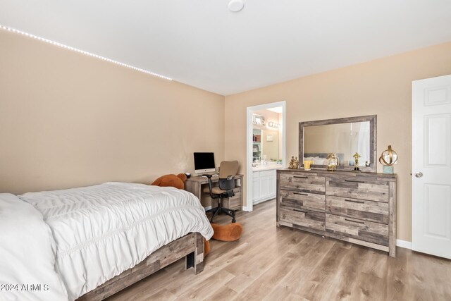 bedroom featuring ensuite bath and light hardwood / wood-style floors