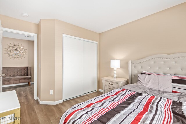 bedroom with light wood-type flooring and a closet