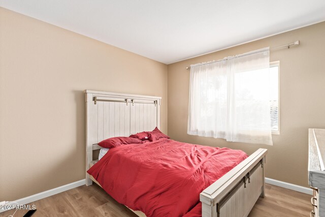 bedroom with light hardwood / wood-style floors and multiple windows