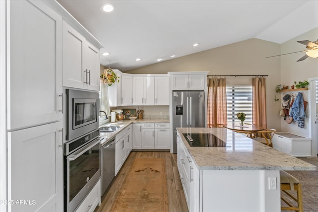 19039 N 47th Ave, Glendale, AZ 85308 - kitchen featuring appliances with stainless steel finishes, light wood-type flooring, a kitchen island, lofted ceiling, and a sink