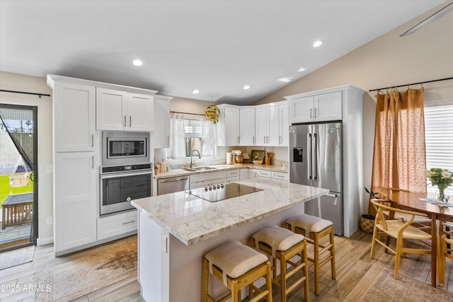 19039 N 47th Ave, Glendale, AZ 85308 - kitchen with appliances with stainless steel finishes, a sink, white cabinetry, a center island, and a breakfast bar area