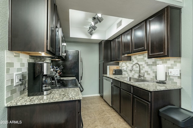 kitchen with visible vents, backsplash, dark brown cabinetry, appliances with stainless steel finishes, and a sink