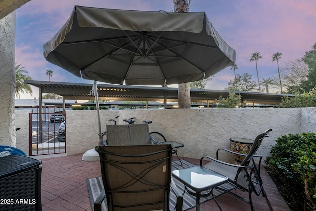 patio terrace at dusk with outdoor dining area and fence