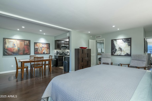 bedroom featuring visible vents, baseboards, dark wood finished floors, washer / dryer, and recessed lighting