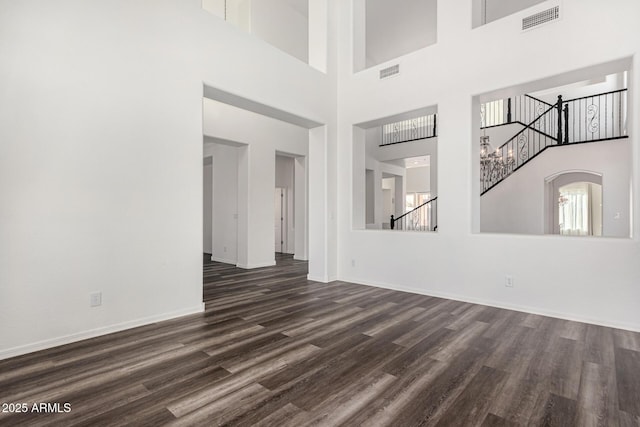 spare room with dark wood-type flooring and plenty of natural light