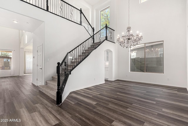 interior space with a high ceiling, hardwood / wood-style floors, and an inviting chandelier