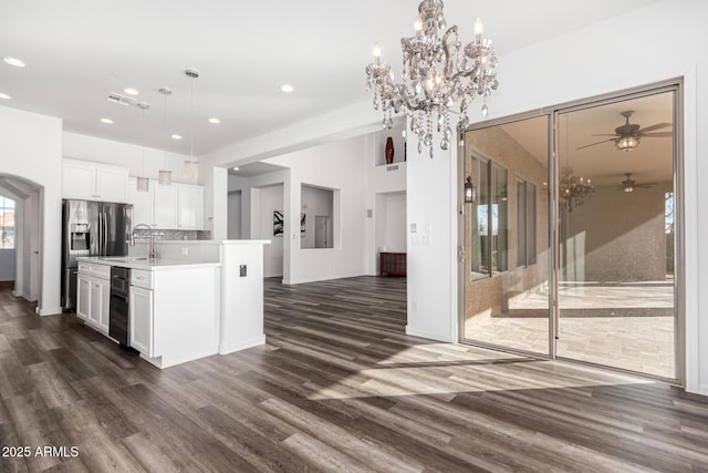 kitchen with decorative light fixtures, sink, white cabinets, dark hardwood / wood-style flooring, and a kitchen island with sink