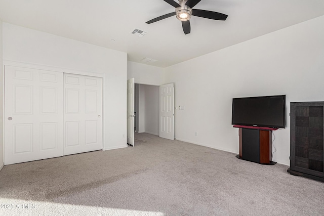 unfurnished bedroom featuring ceiling fan, a closet, and light carpet