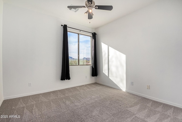 carpeted empty room featuring a mountain view and ceiling fan