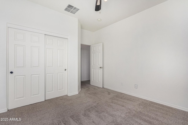 unfurnished bedroom with ceiling fan, carpet flooring, and a closet