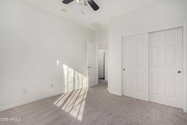 unfurnished bedroom with light carpet, ceiling fan, and a closet