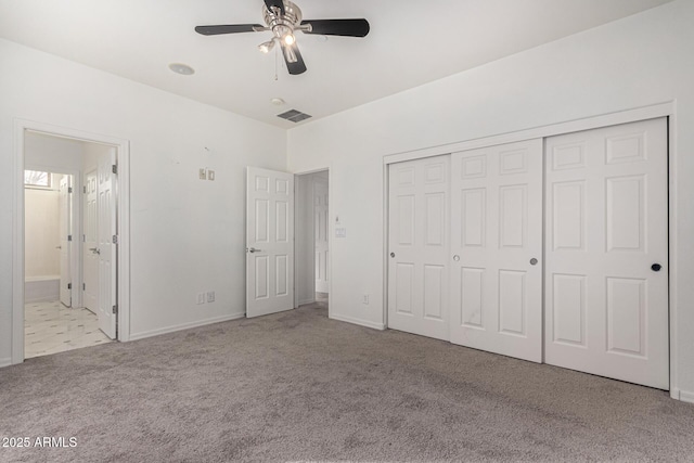 unfurnished bedroom with light carpet, a closet, ceiling fan, and ensuite bathroom