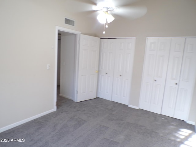 5323 W N Ln, Glendale, AZ 85302 - unfurnished bedroom featuring two closets, dark carpet, and a ceiling fan