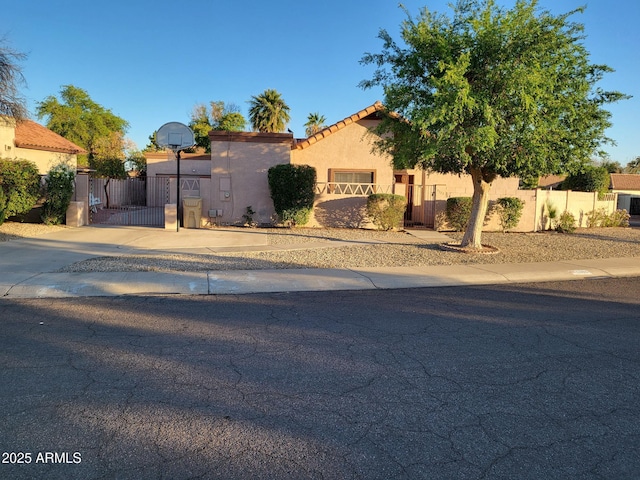5323 W N Ln, Glendale, AZ 85302 - mediterranean / spanish-style house featuring a gate, stucco siding, a tiled roof, and concrete driveway
