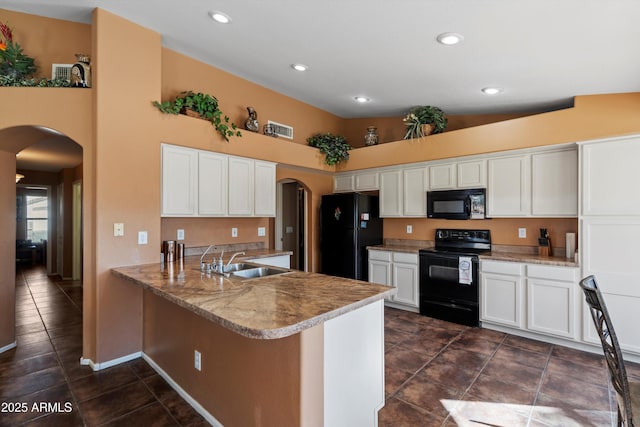 kitchen featuring white cabinetry, sink, kitchen peninsula, a towering ceiling, and black appliances