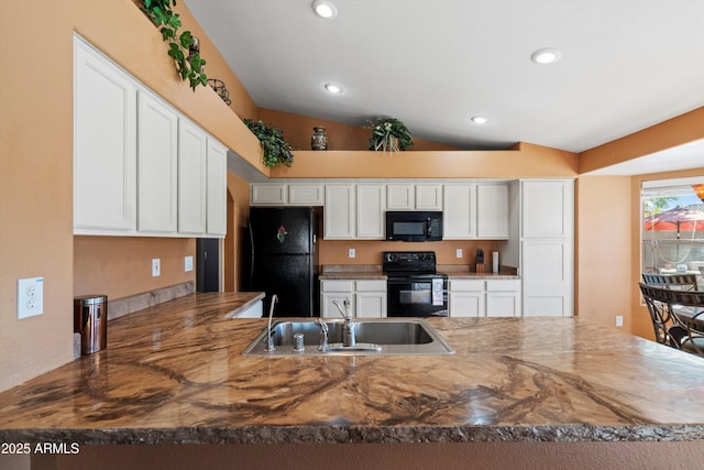 kitchen featuring white cabinetry, sink, kitchen peninsula, vaulted ceiling, and black appliances