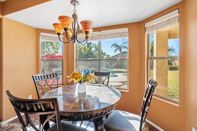 tiled dining room featuring a healthy amount of sunlight and an inviting chandelier