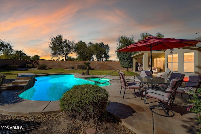 pool at dusk with a patio and a lawn