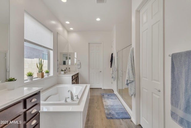 22927 E Via Del Oro, Queen Creek, AZ 85142 - bathroom featuring vanity, a garden tub, a stall shower, wood finished floors, and recessed lighting