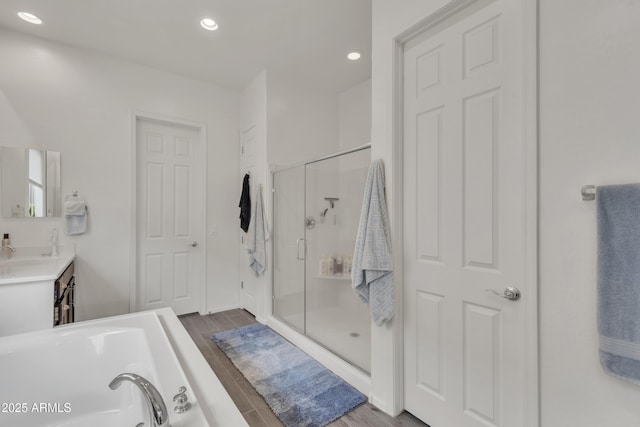 22927 E Via Del Oro, Queen Creek, AZ 85142 - bathroom with a stall shower, wood finished floors, a garden tub, vanity, and recessed lighting