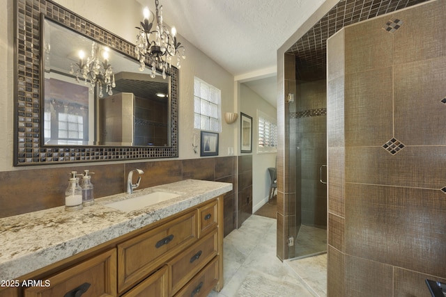 full bathroom with a textured ceiling, tile walls, a shower stall, and vanity