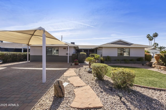 view of front facade with a carport, decorative driveway, and brick siding