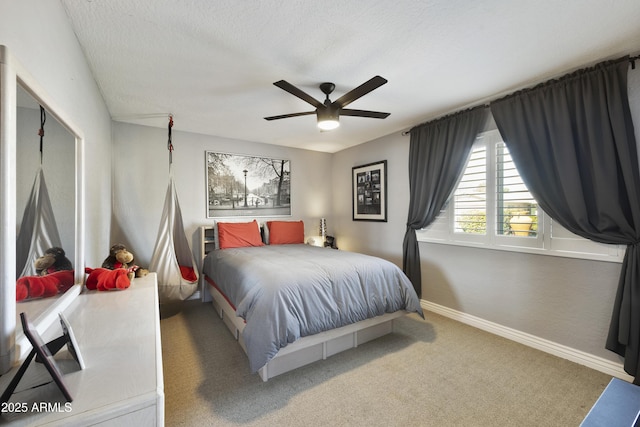 bedroom with a ceiling fan, a textured ceiling, baseboards, and carpet flooring