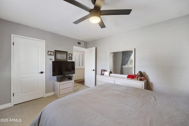 bedroom featuring light carpet, baseboards, visible vents, and a ceiling fan