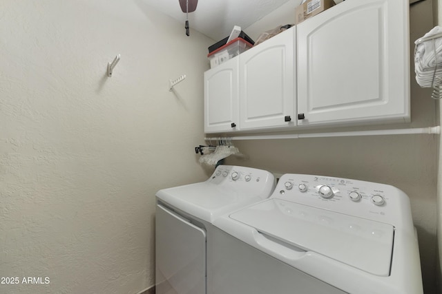 laundry area with a textured wall, independent washer and dryer, and cabinet space