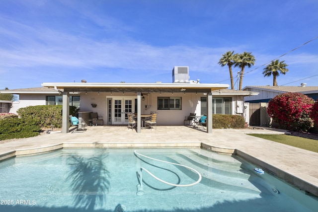 rear view of property with ceiling fan, central air condition unit, french doors, an outdoor pool, and a patio area