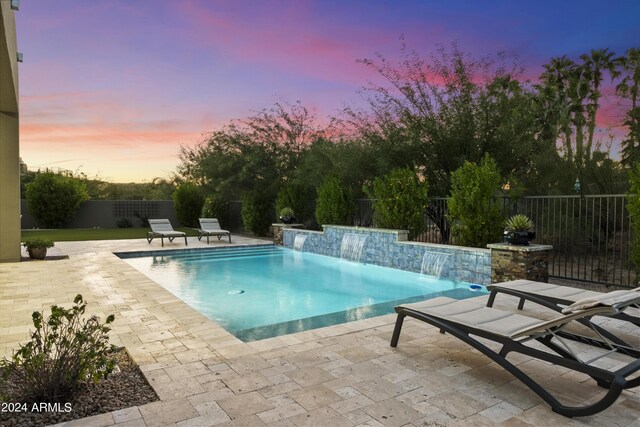 back house at dusk with a yard and a patio area